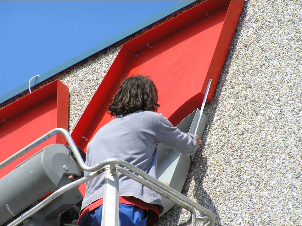 Installing a red sign on a building façade