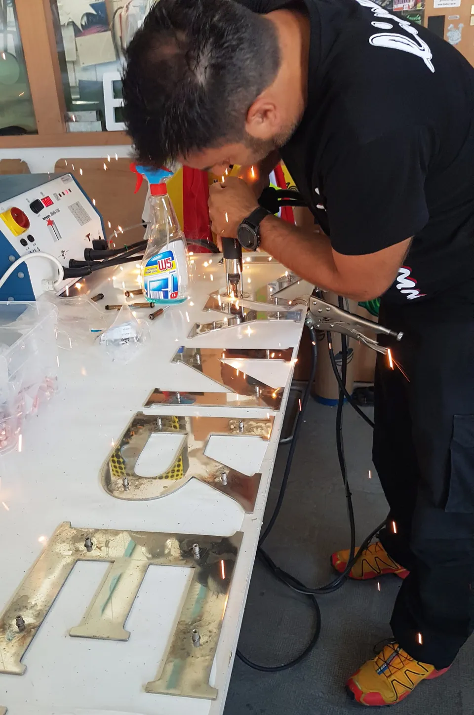 A Lineta craftsman assembling metal 3D letters in the workshop